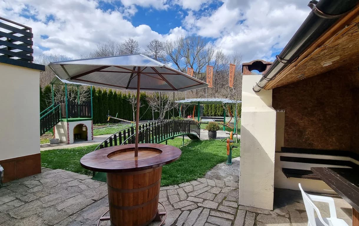Дворът с барбекю, маса и чадър